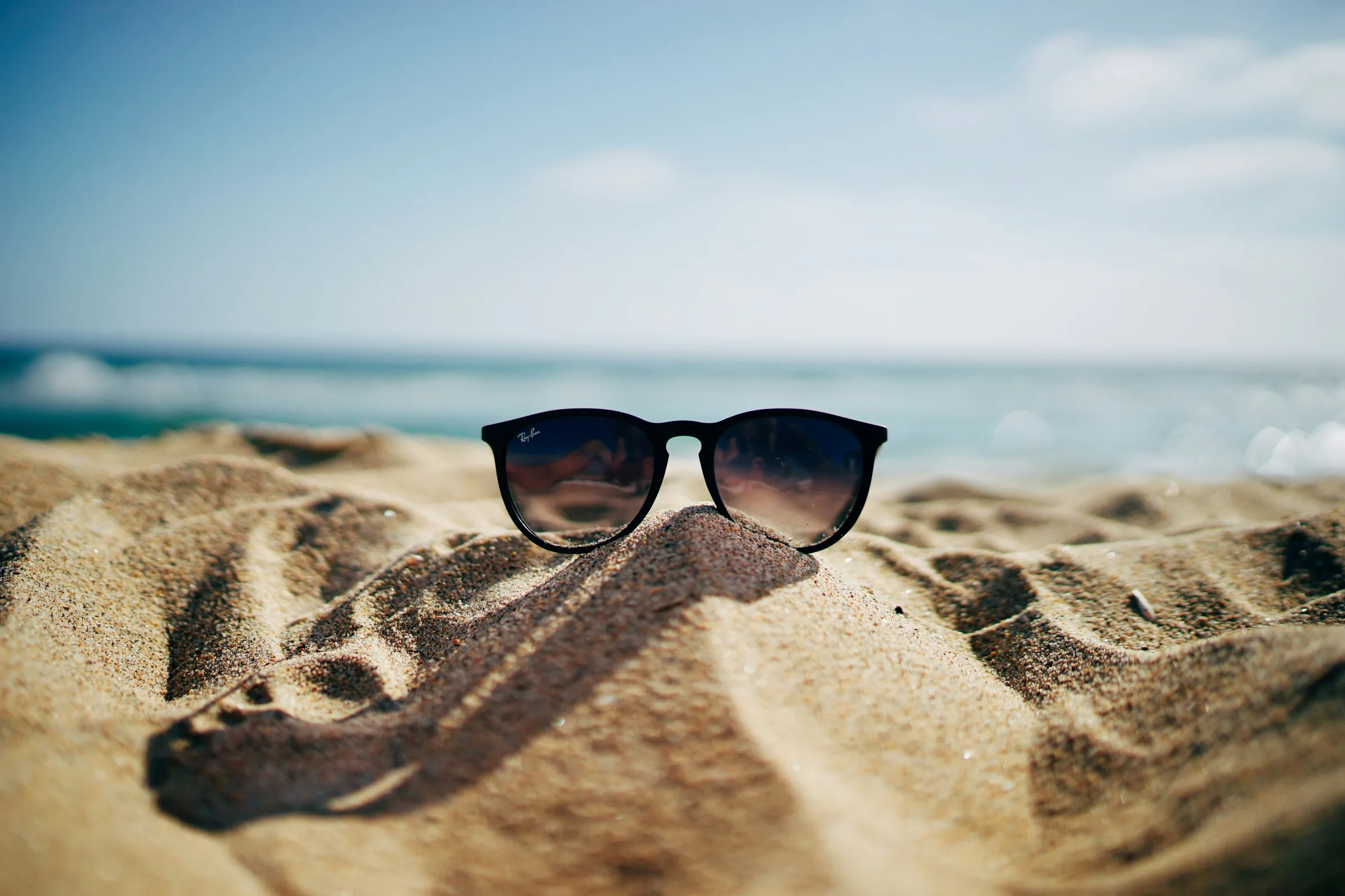Lunettes de soleil posées sur le sable