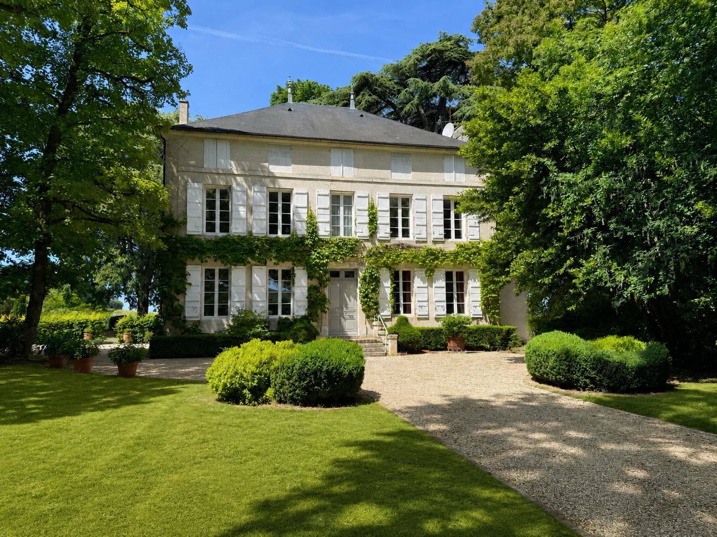 Villa élégante entourée de verdure luxuriante et de jardins bien entretenus.