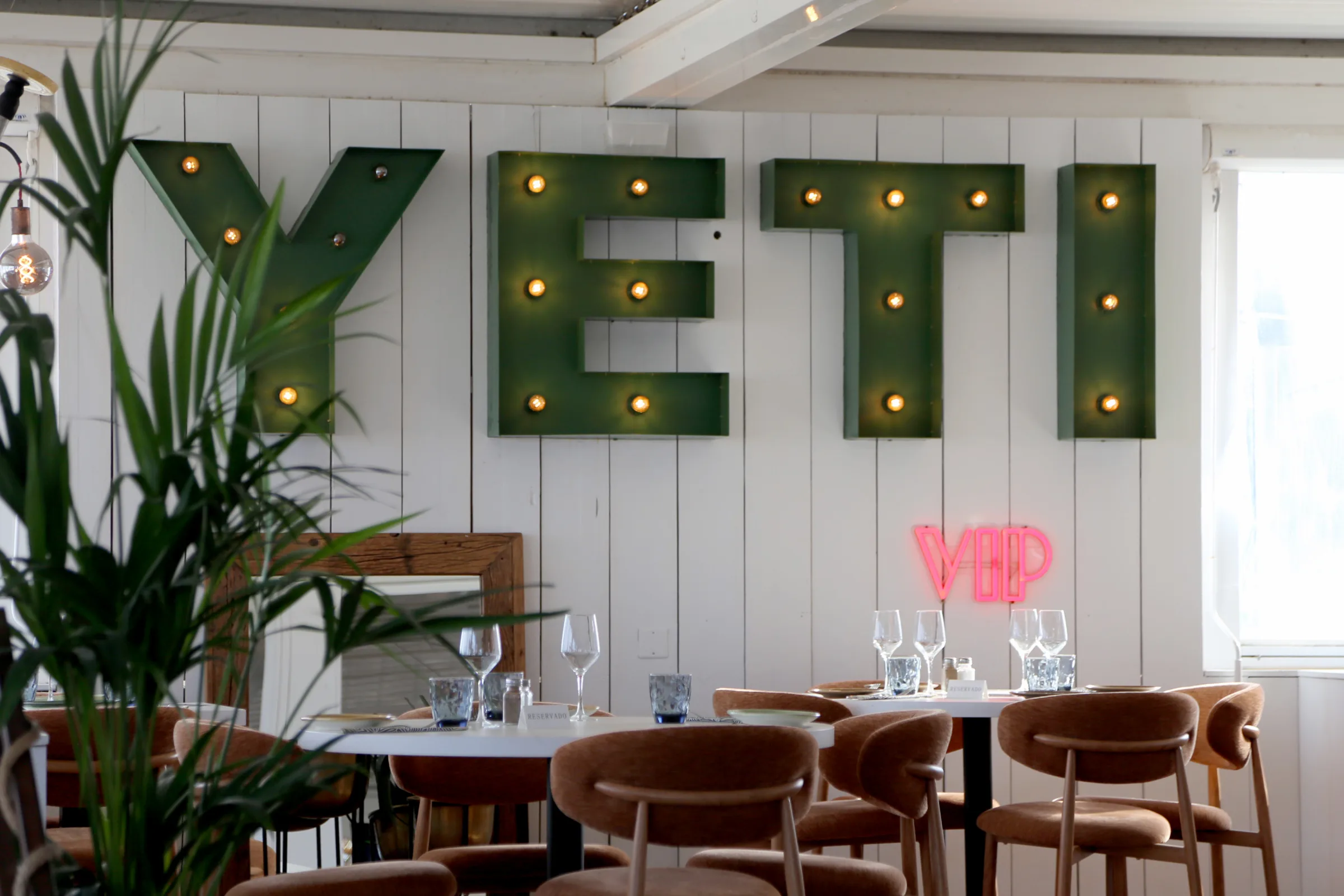 Interior of YETI restaurant with green letters and VIP sign