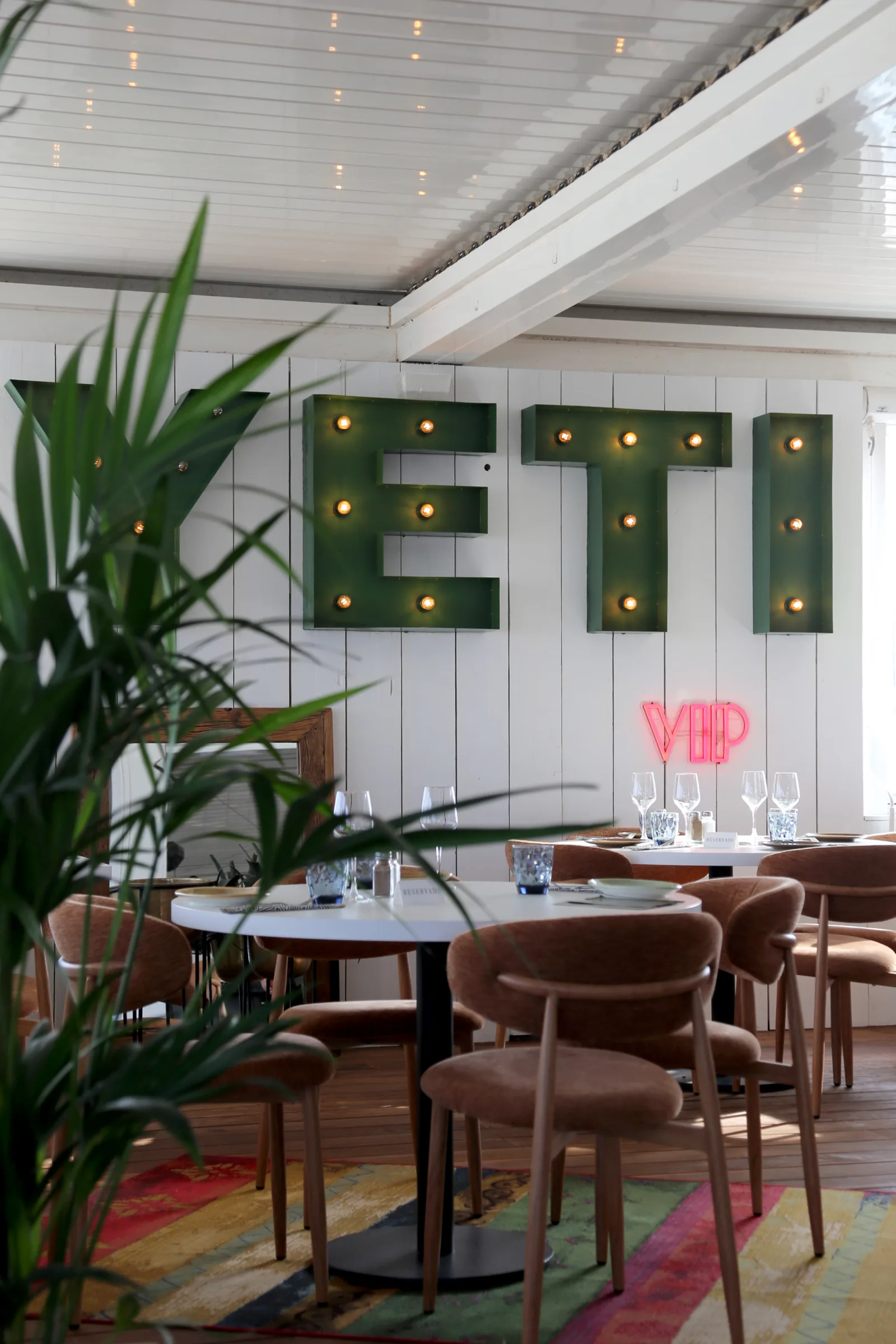 Interior of YETI restaurant with green letters and a neon sign
