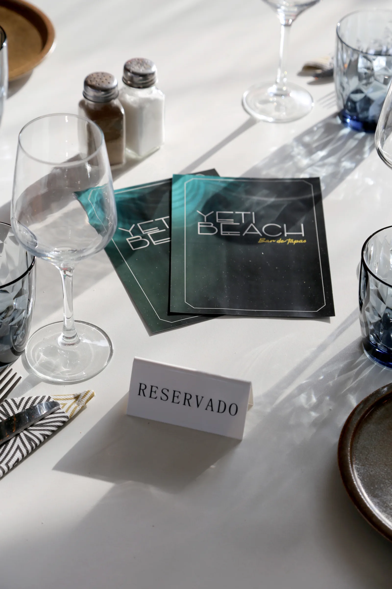 Reserved table setting at Yeti Beach restaurant with menus.