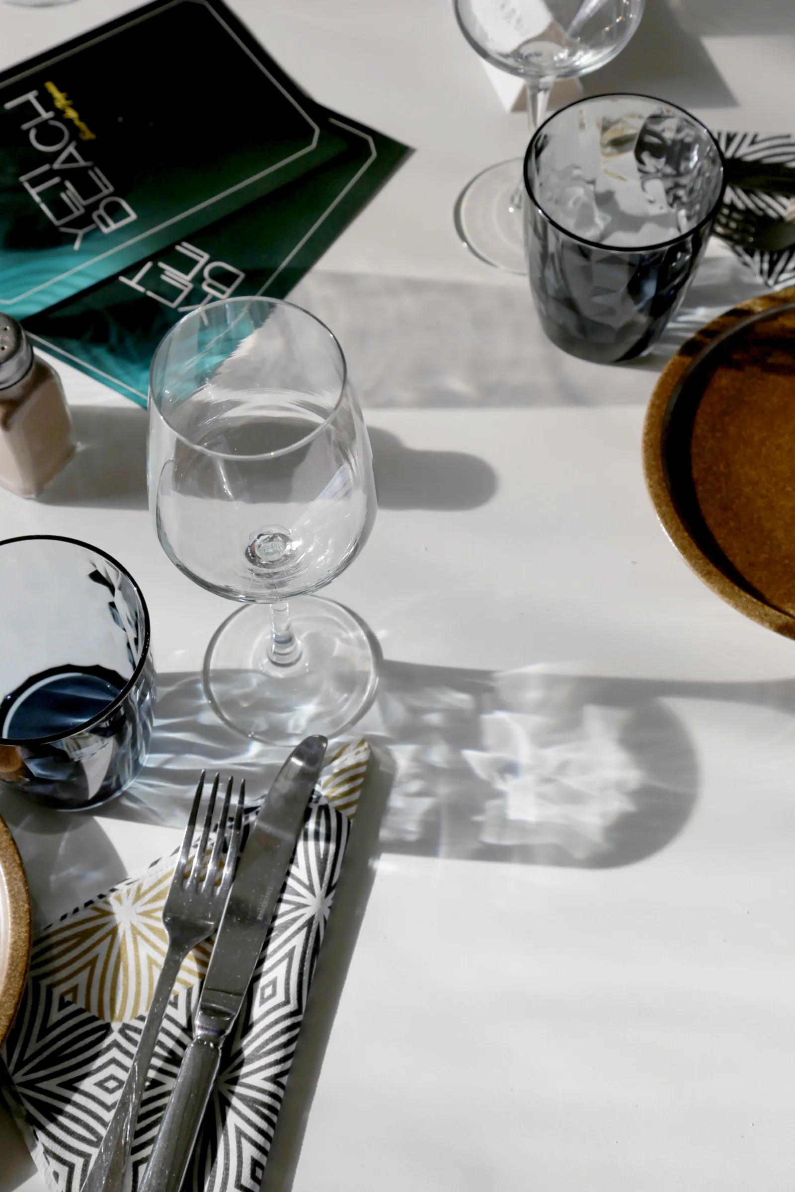 Table setting with glasses, plates, and utensils at a restaurant