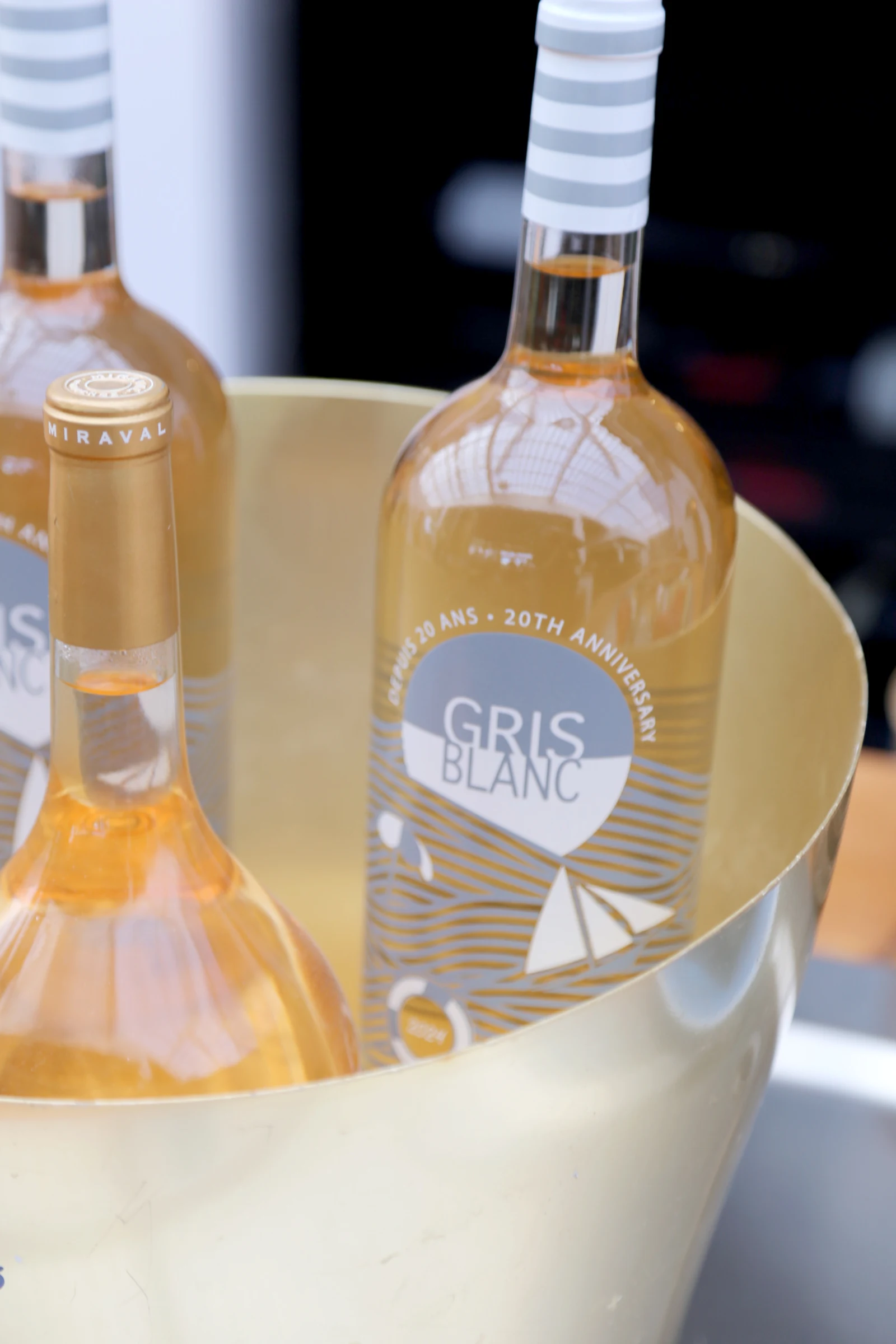 Chilled bottle of Gris Blanc wine in a gold ice bucket.
