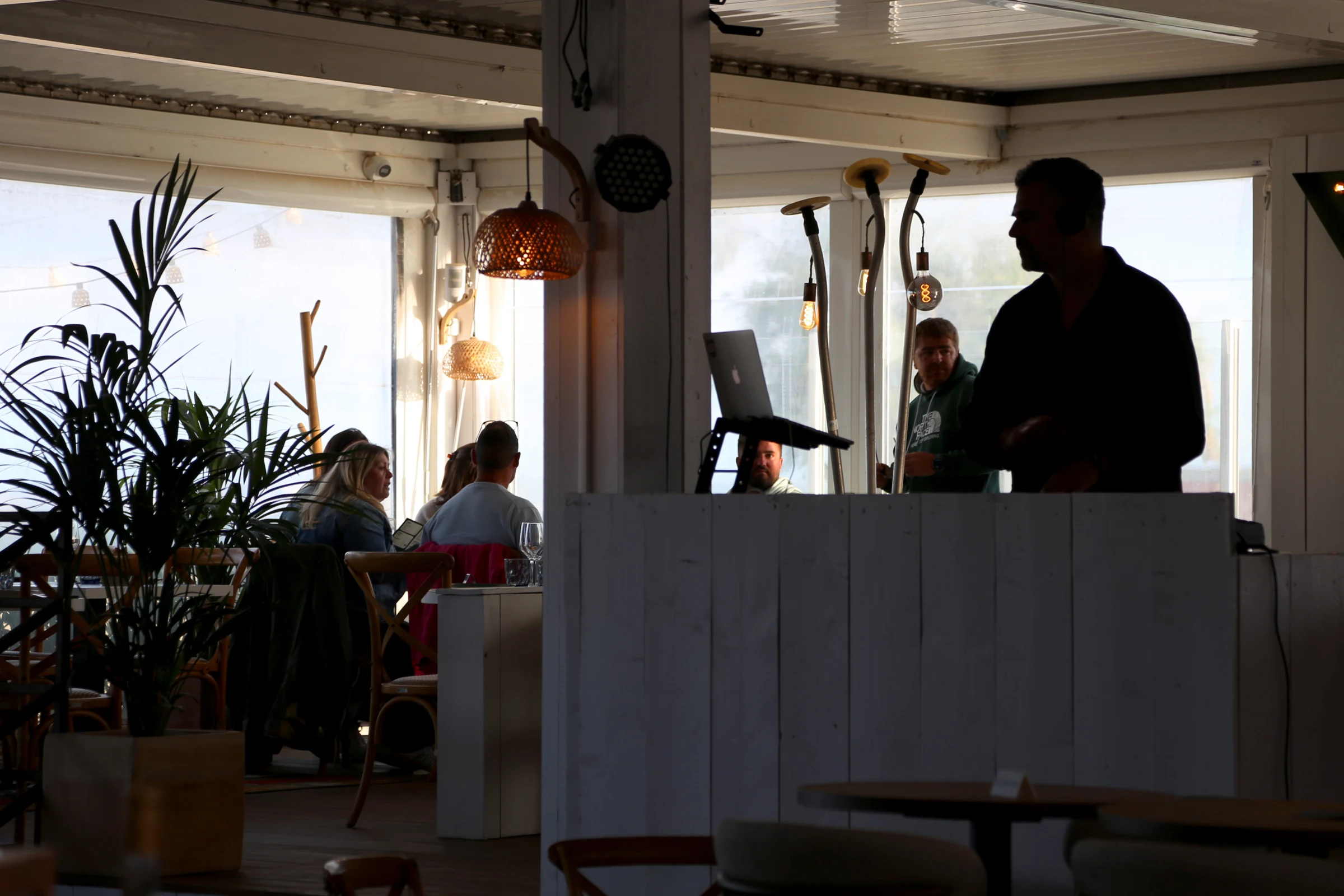 Interior of a restaurant with patrons and a DJ booth