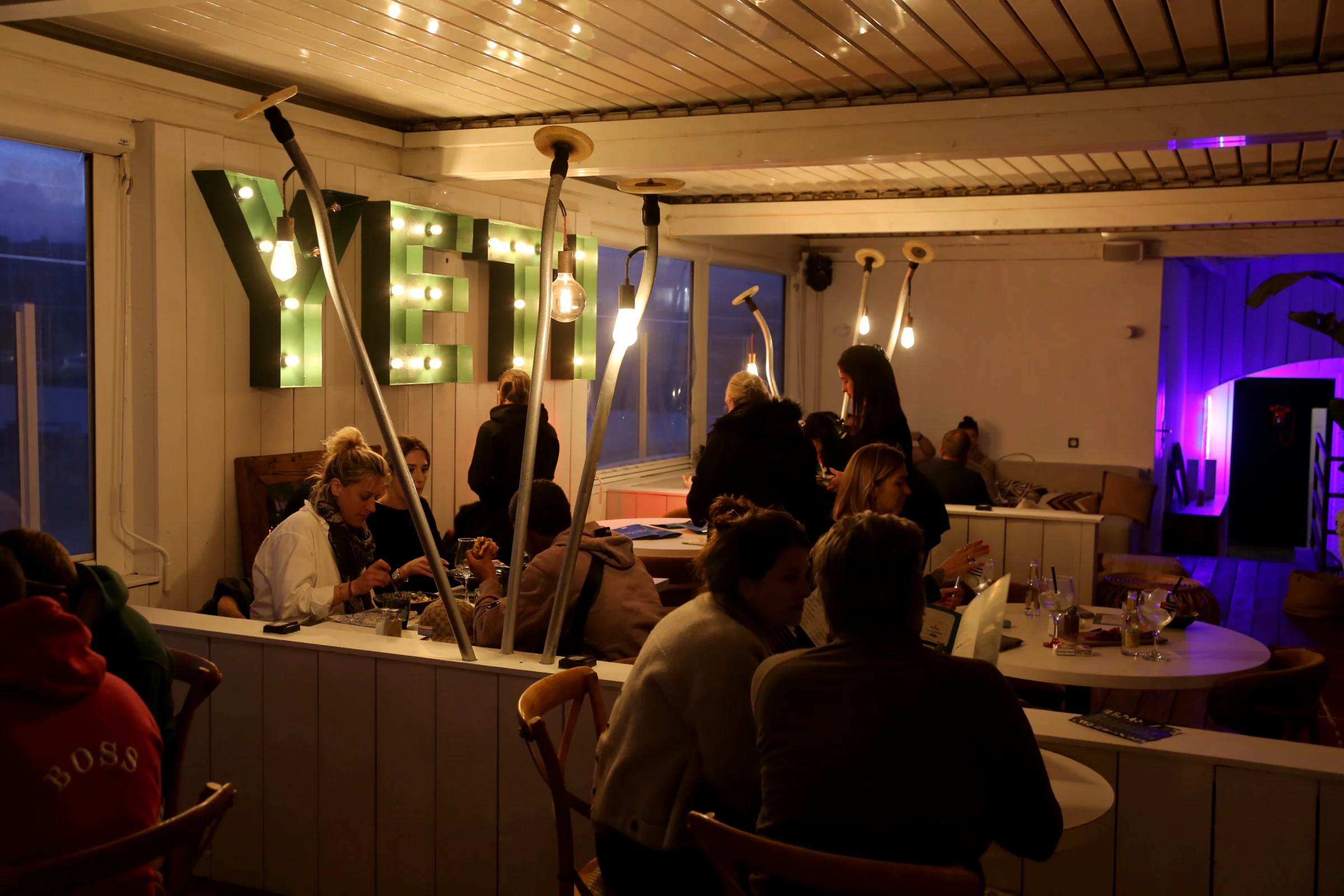 Interior of YETI restaurant with patrons dining and unique lighting.