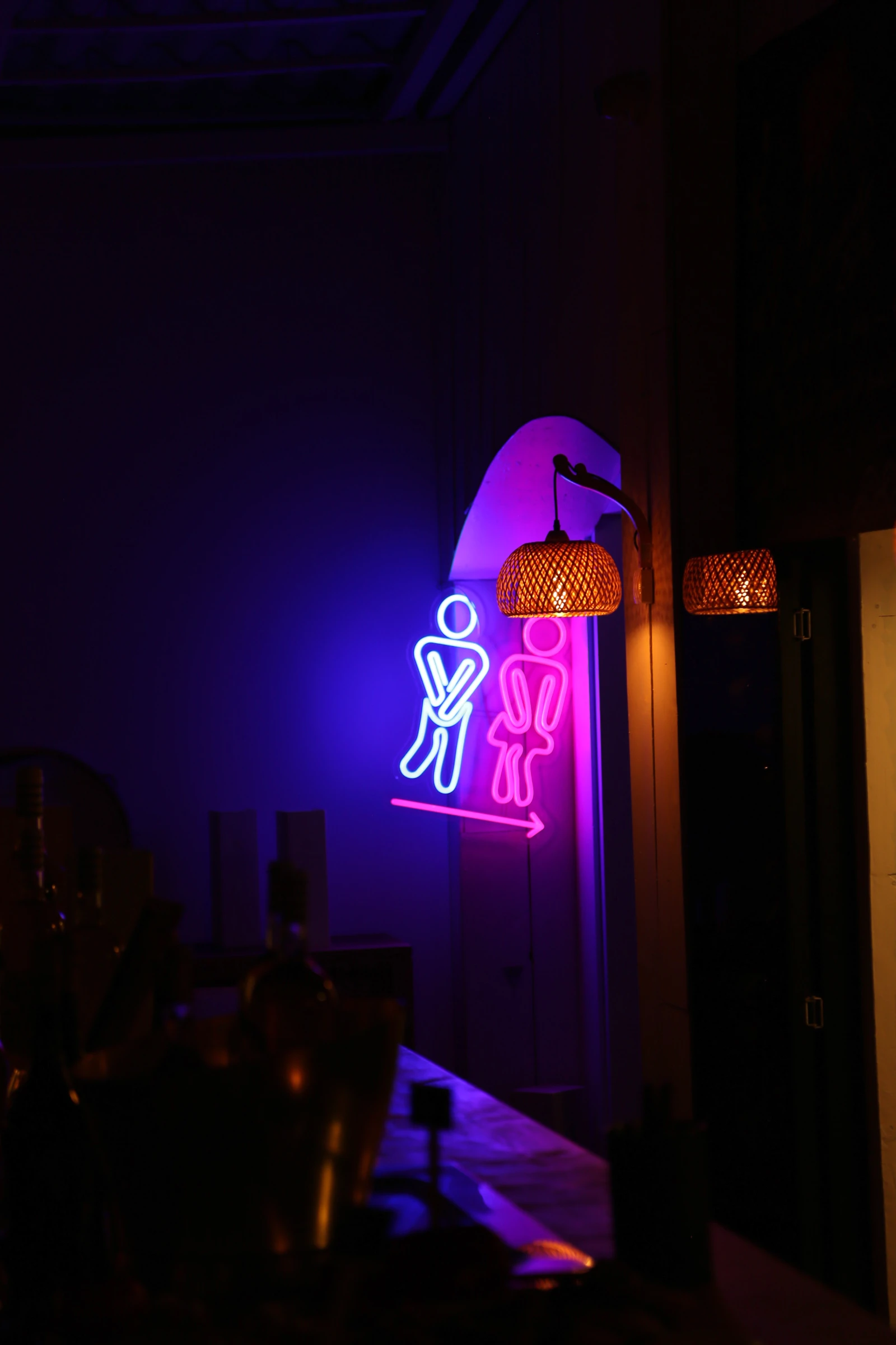Neon sign indicating men's restroom with playful design.