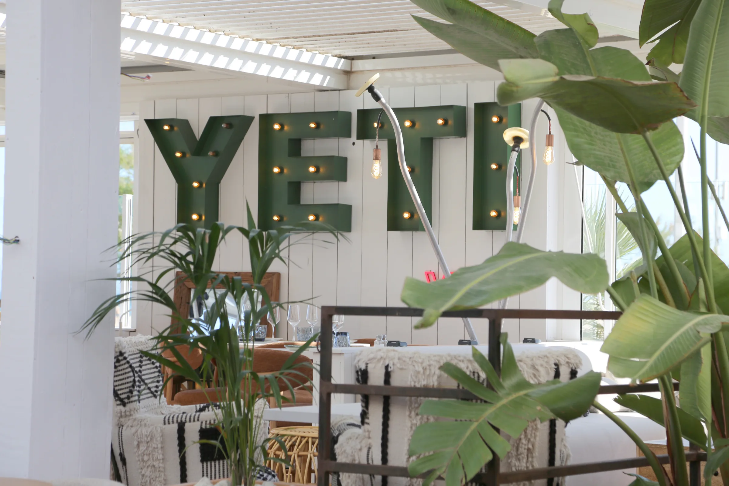 Interior of YETI restaurant with green signage and plants.