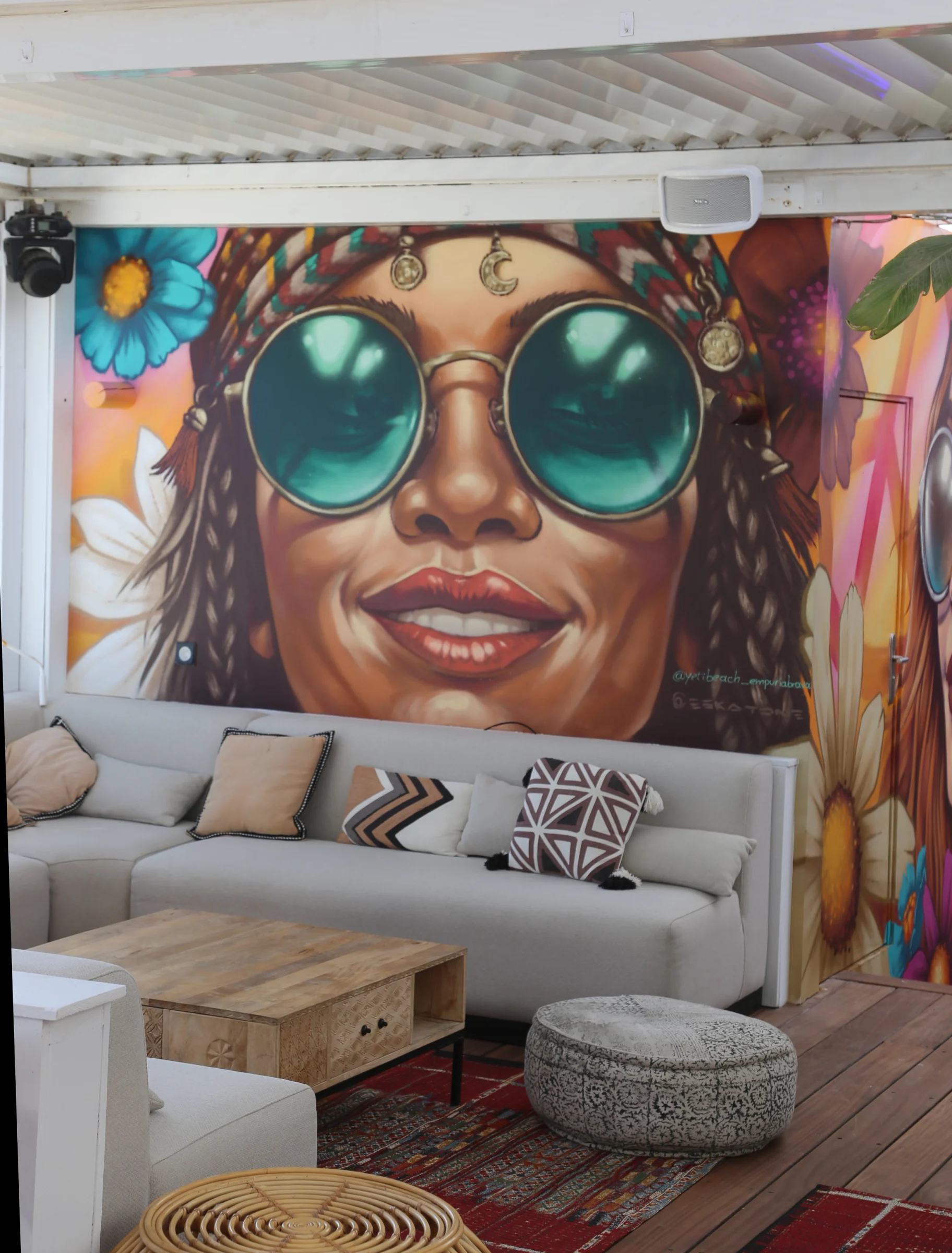 Colorful mural of a woman with sunglasses in a restaurant interior.