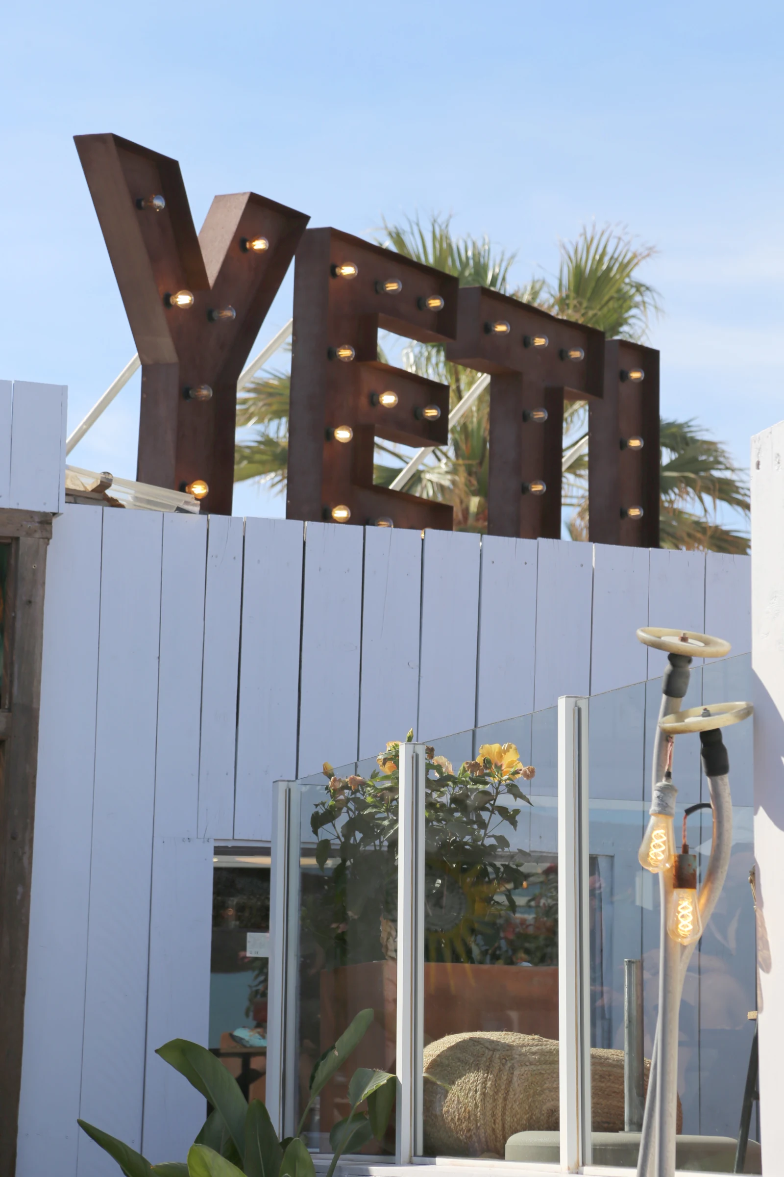 YETI restaurant sign with lights and palm trees in the background