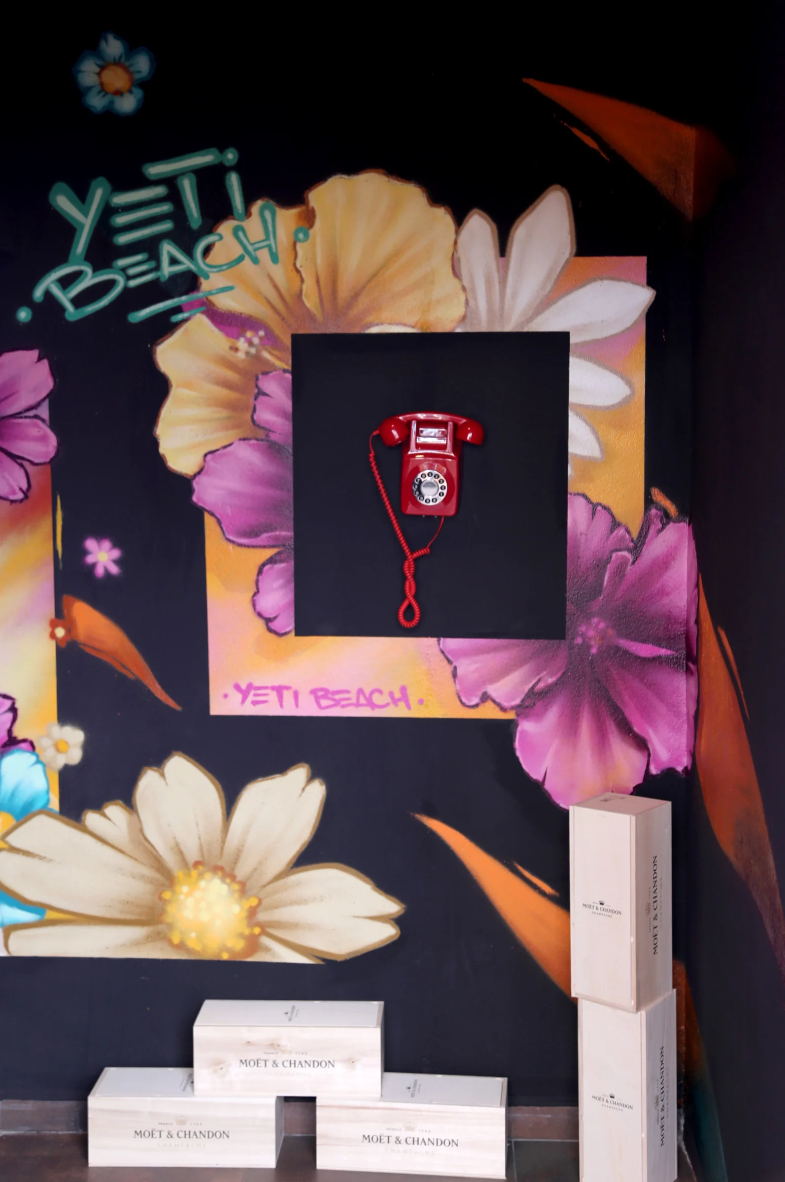 Colorful mural with a vintage red telephone and floral designs