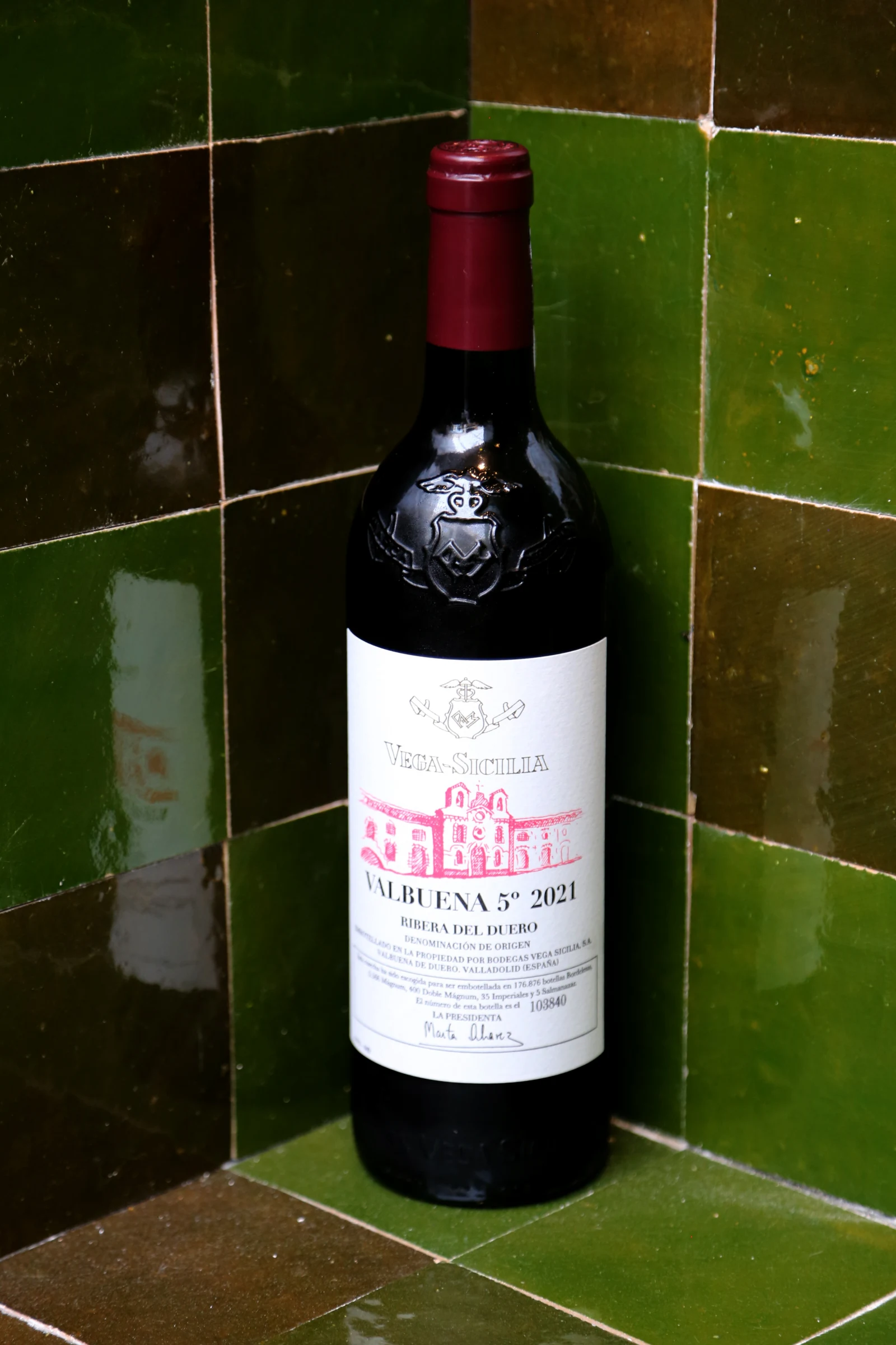 Bottle of Valbuena 5 wine against a green tiled background.