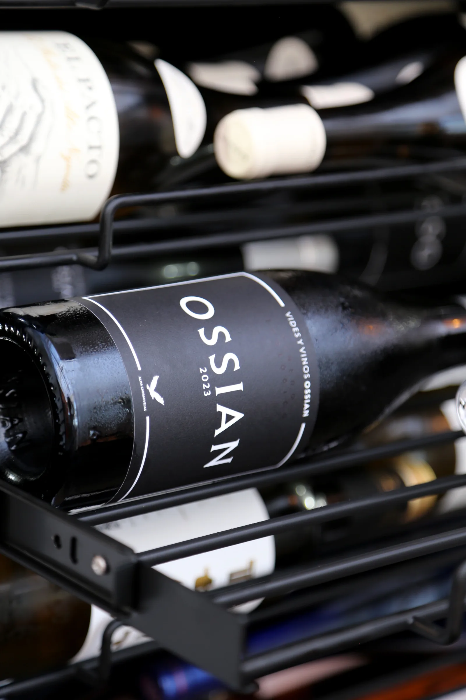Bottle of Ossian wine on a rack among other bottles.