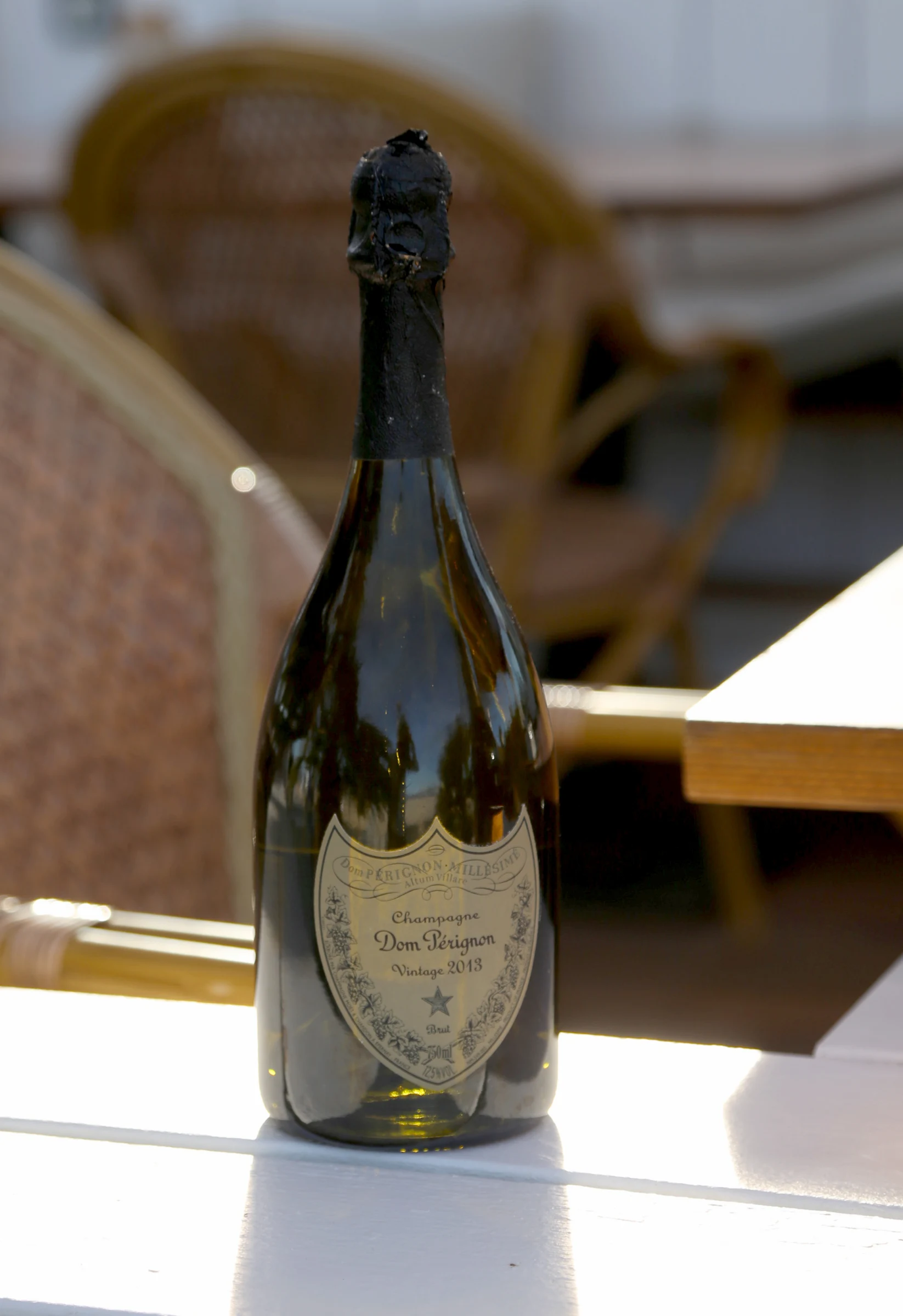 Bottle of Dom Pérignon vintage 2013 champagne on a table.