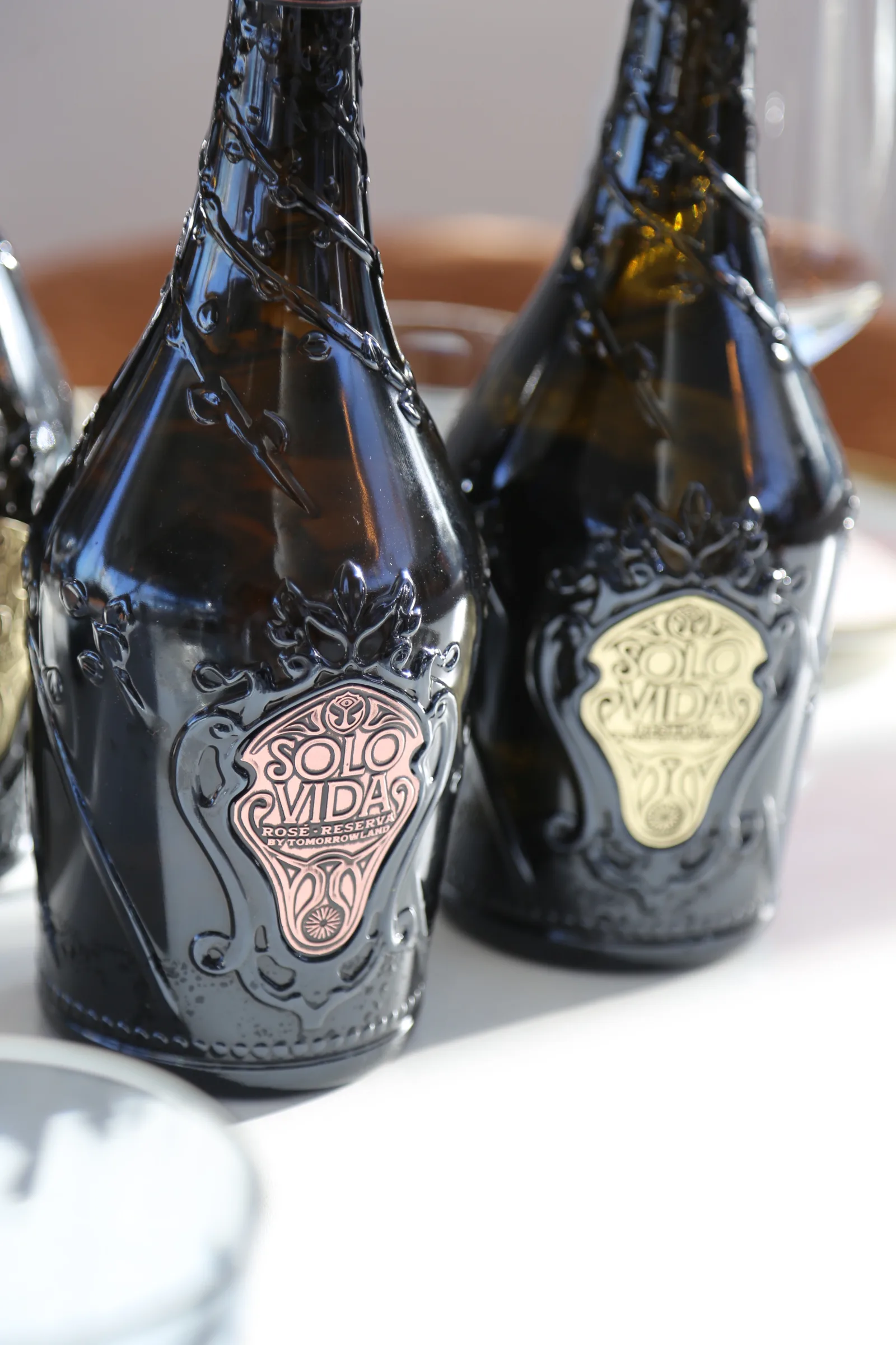 Two elegant bottles of Solo Vidas wine on a table.