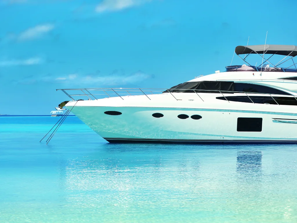 Luxury yacht anchored in clear blue waters under a bright sky.