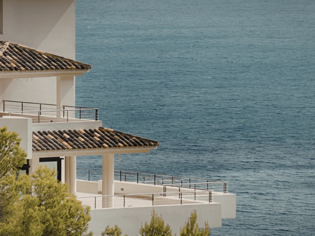 Modern villa overlooking the sea with a tiled roof and terrace.