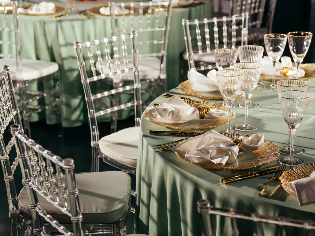 Elegant dining setup with green tablecloths and crystal glassware.