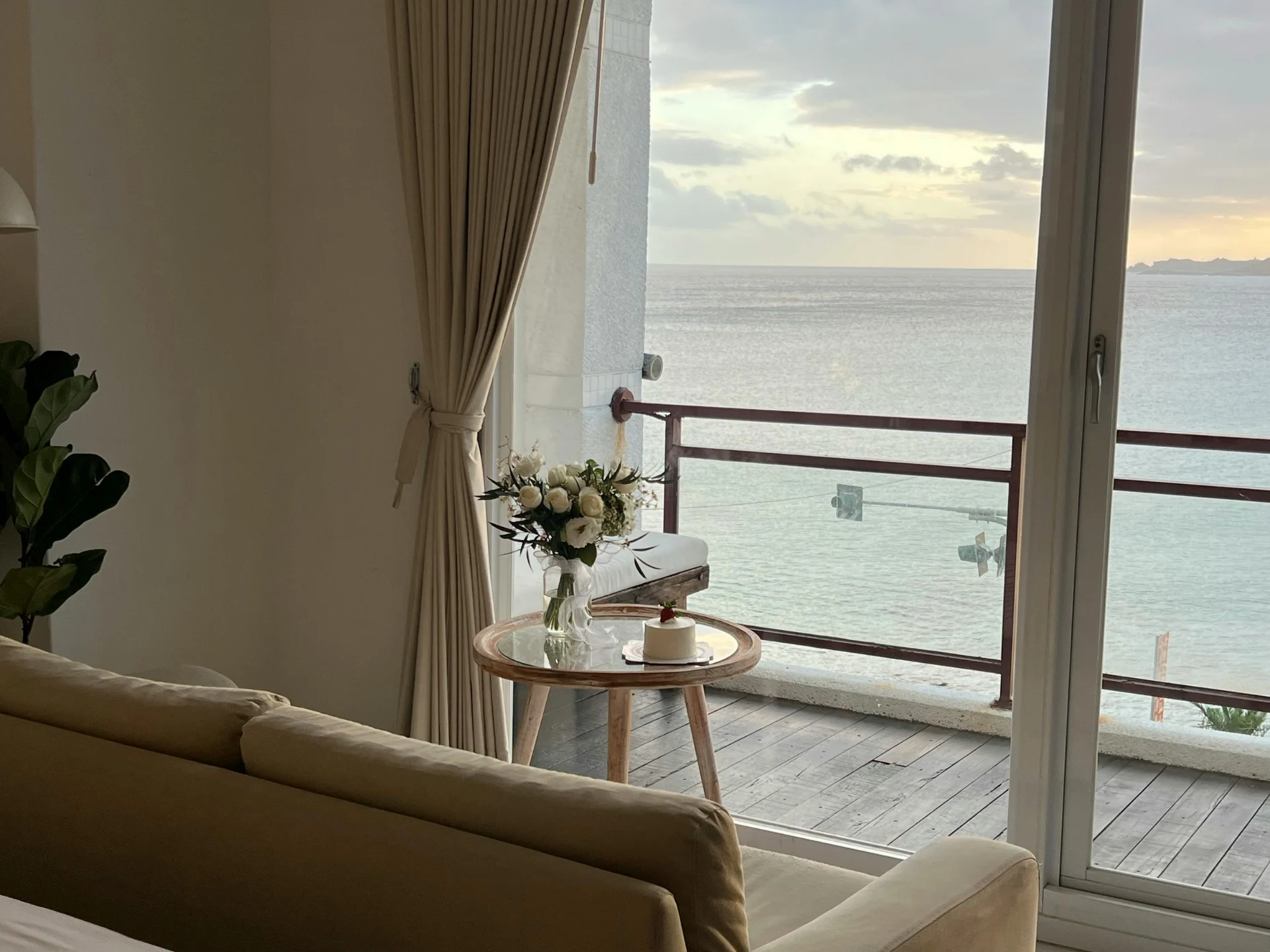 Cozy interior with a view of the ocean and a flower arrangement on a table.