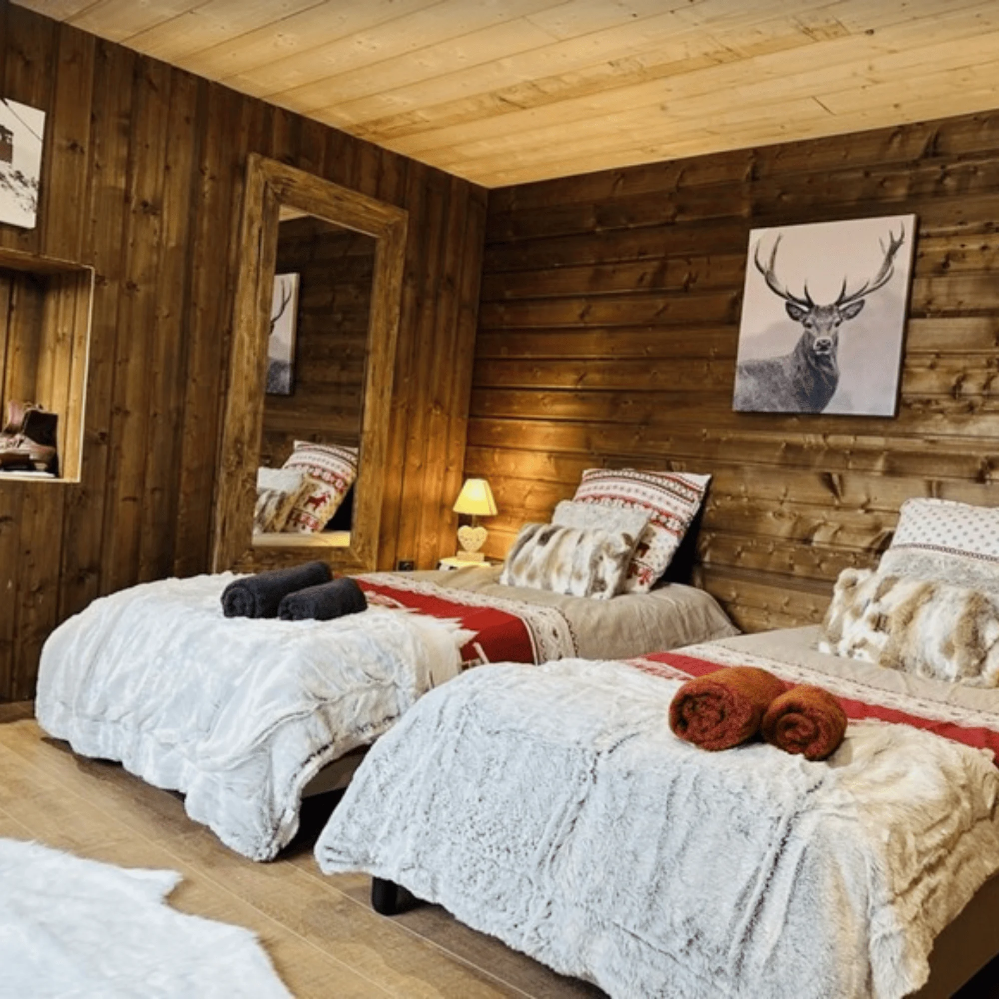 Chambre confortable avec deux lits, décor en bois et accessoires chaleureux.