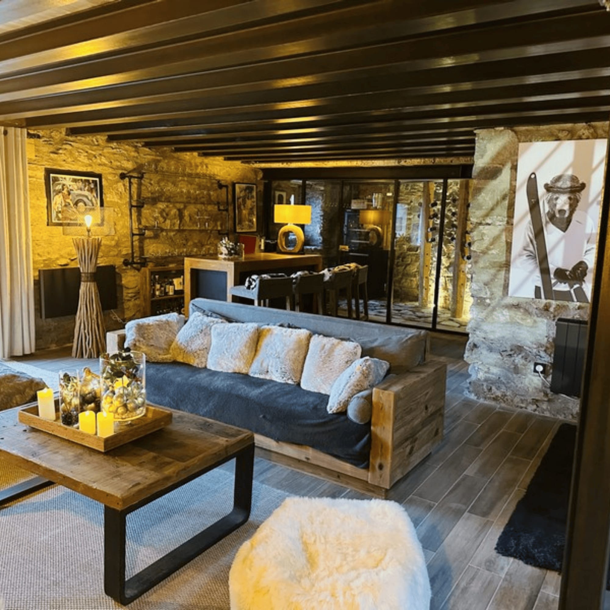 Intérieur d'un chalet avec un salon confortable et une décoration en pierre.