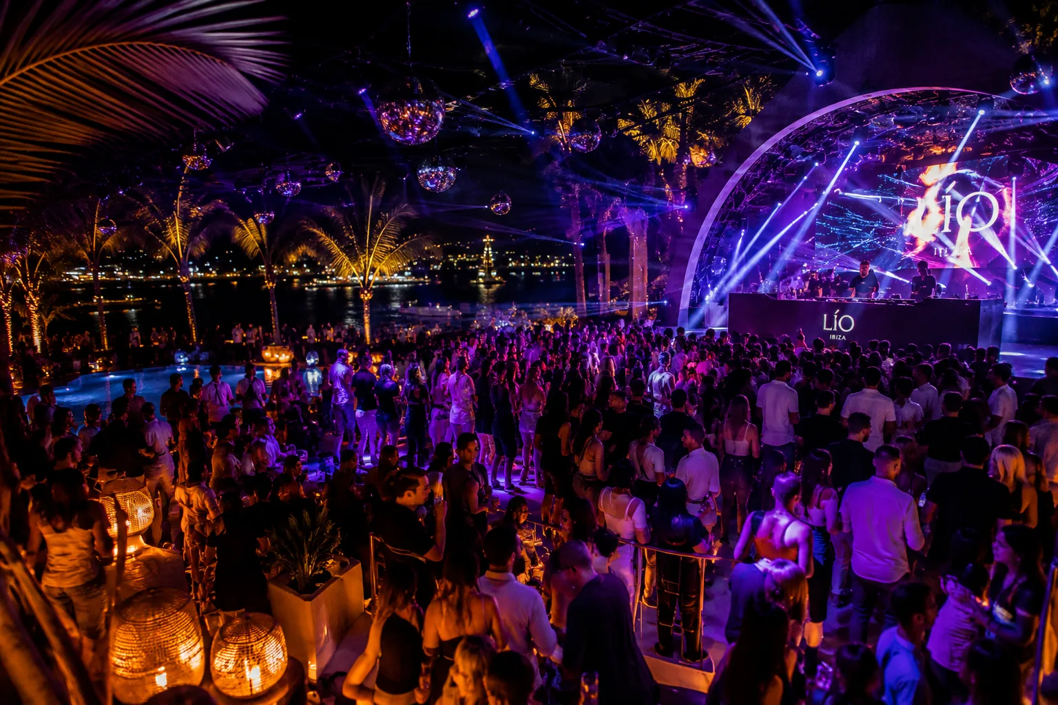 Party at a nightclub with bright lights and a crowd of people.